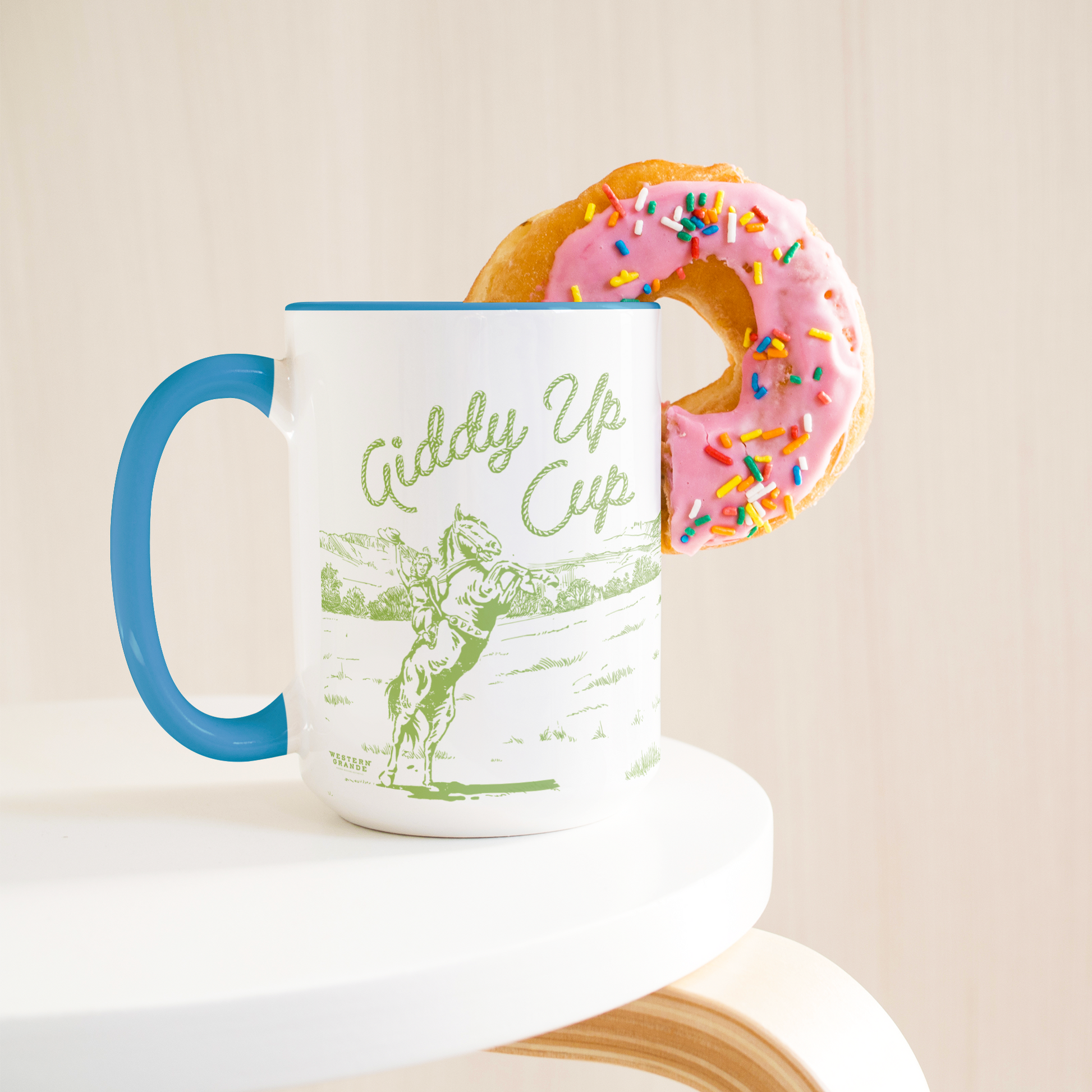 GIDDY_UP_CUP_-BLUE_MUG__GREEN_ART-_15oz_Lifestyle_Donut_LH_Mockup.png_15383353